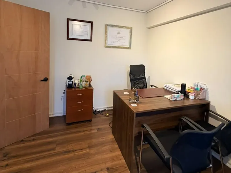 Escritorio de la oficina 409 en Caupolicán 567, con diplomas enmarcados en la pared